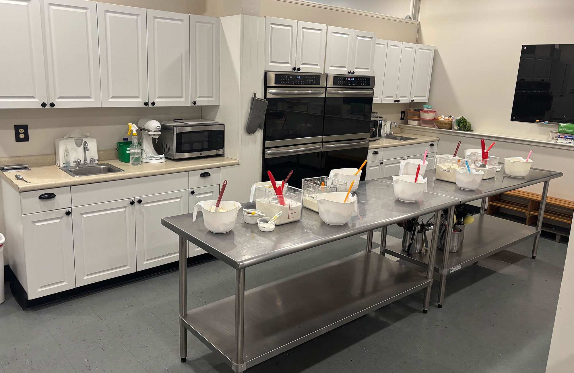 Kitchen from alternate angle with cooking bowls and food on table