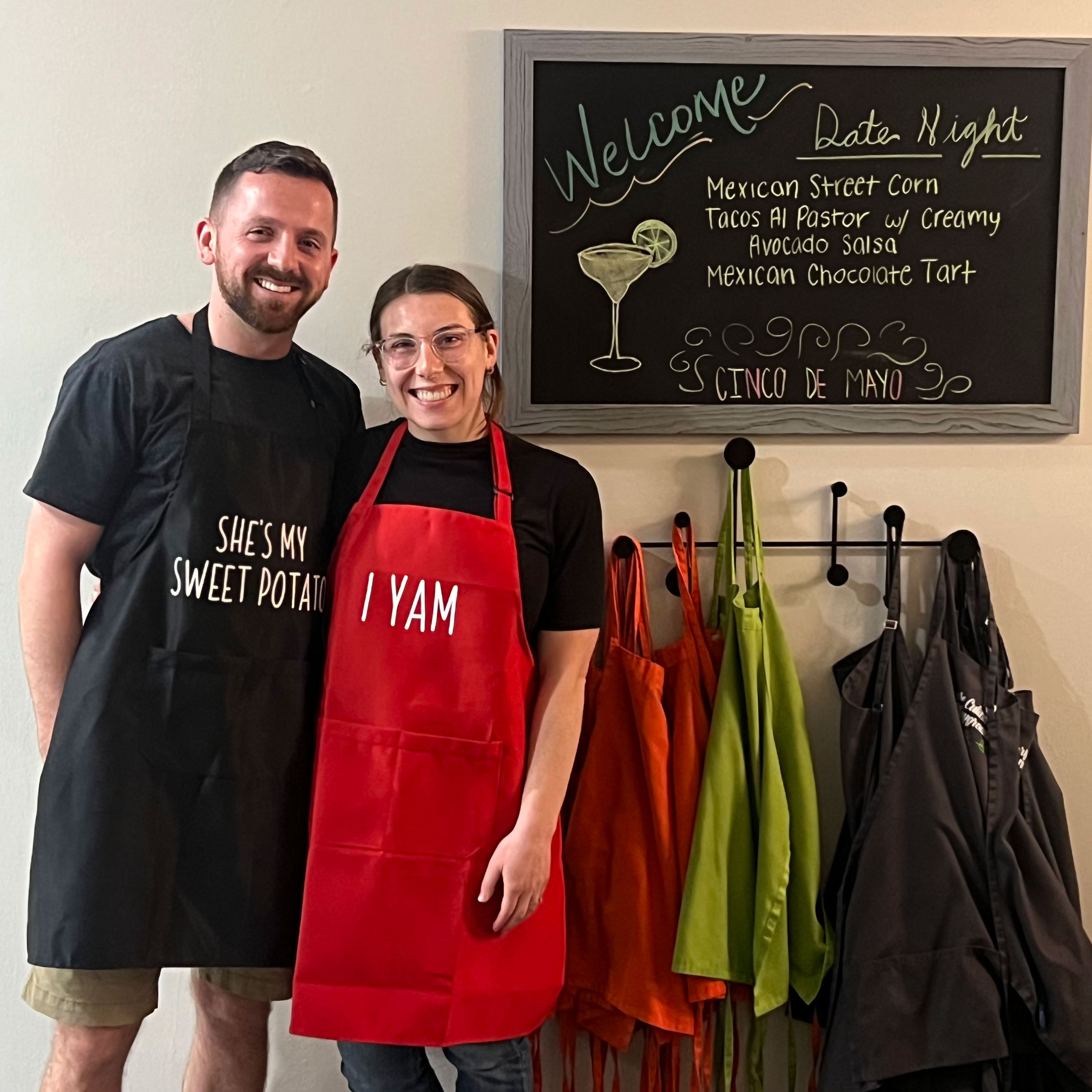 Man and woman smiling together in front of board that reads date night